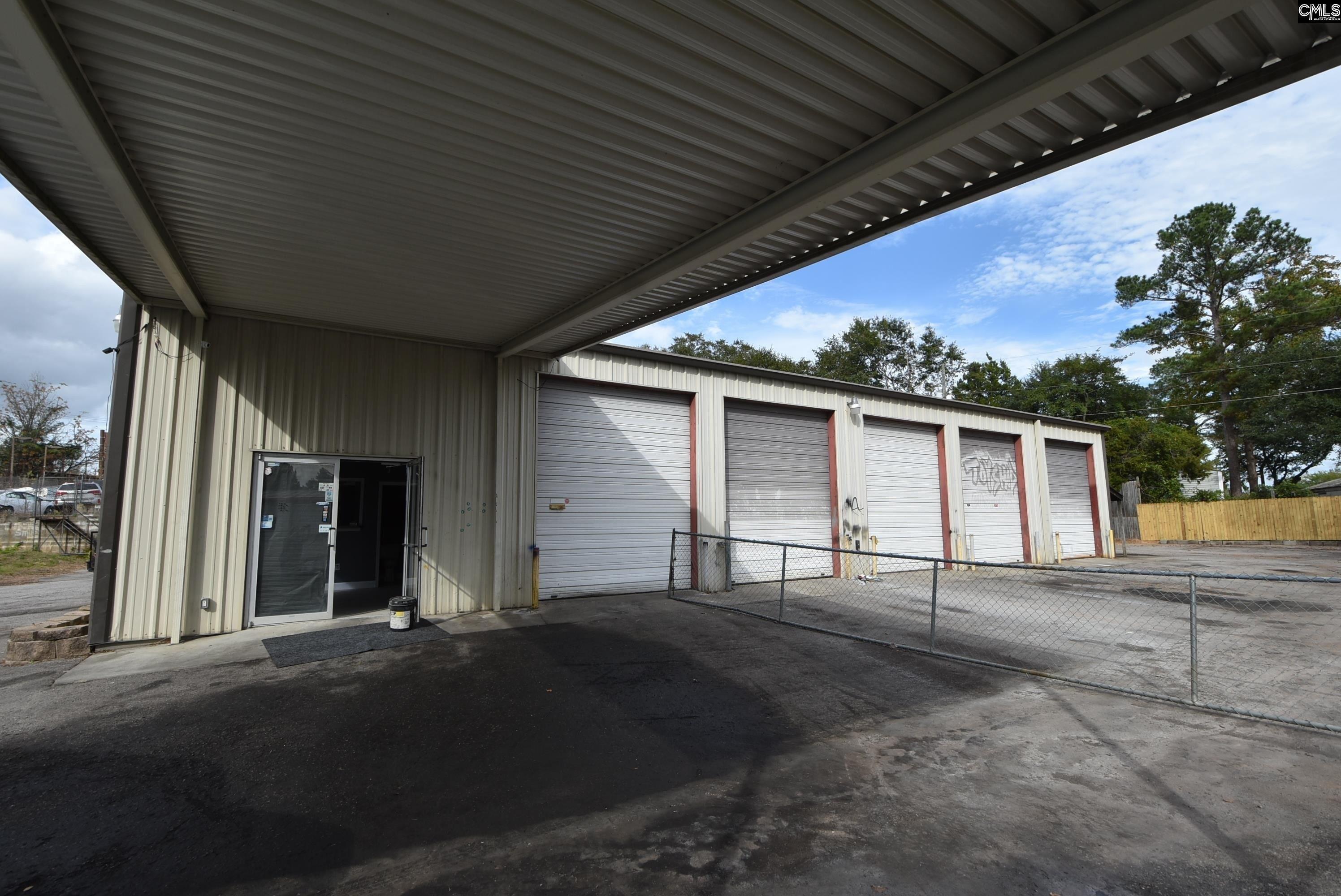Covered canopy overhang and entry to customer counter, with roll-up bays beyond
