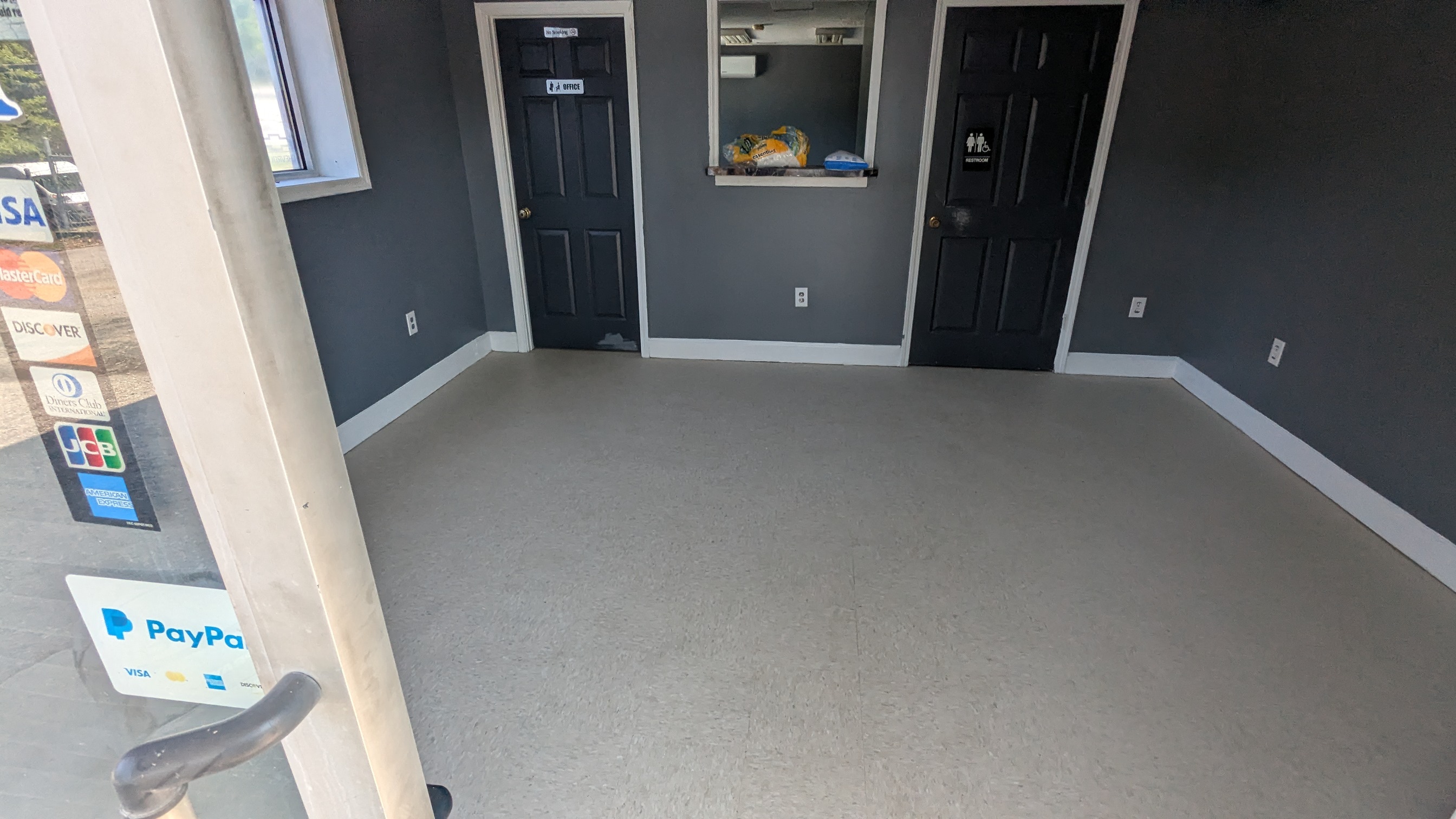 Customer lobby interior — service window, office door, restroom, payment acceptance at entry