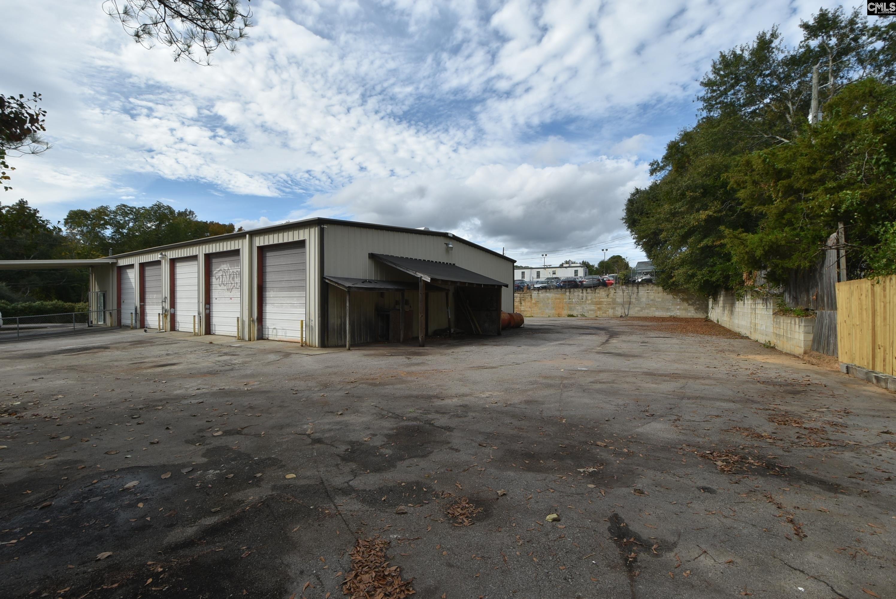 Wide view of paved yard showing all five roll-up bays and lot depth