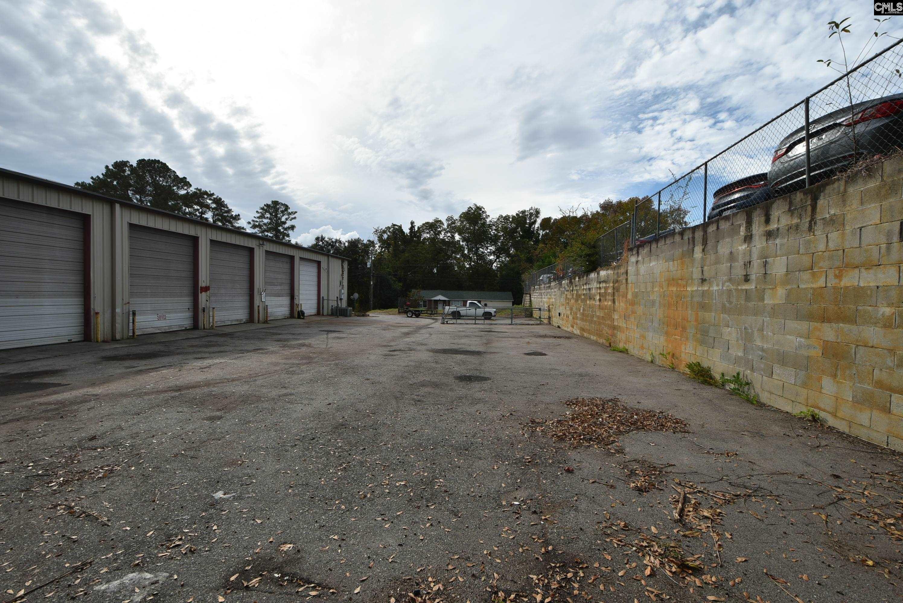 Side lot enclosed by masonry block retaining wall and privacy fence — secured perimeter