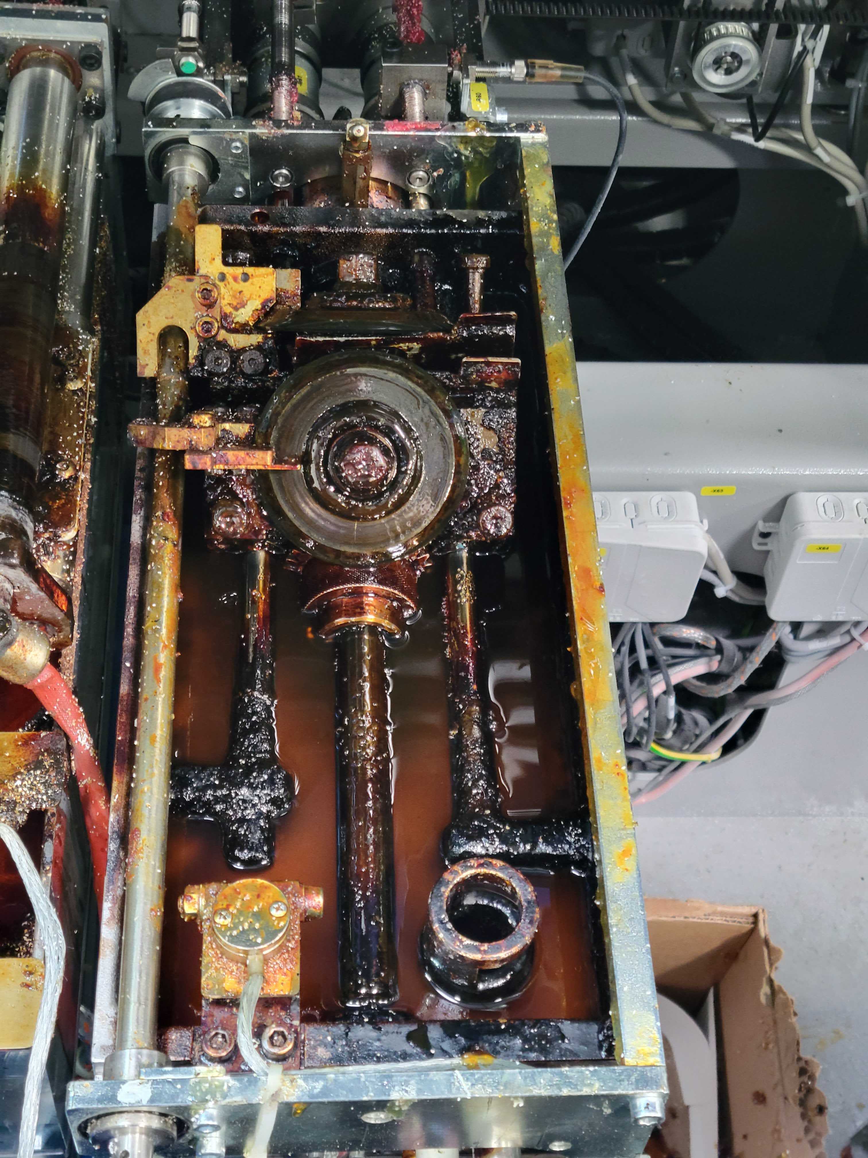 Glue applicator interior photographed in place inside Amazon equipment — adhesive flooded, wiring live